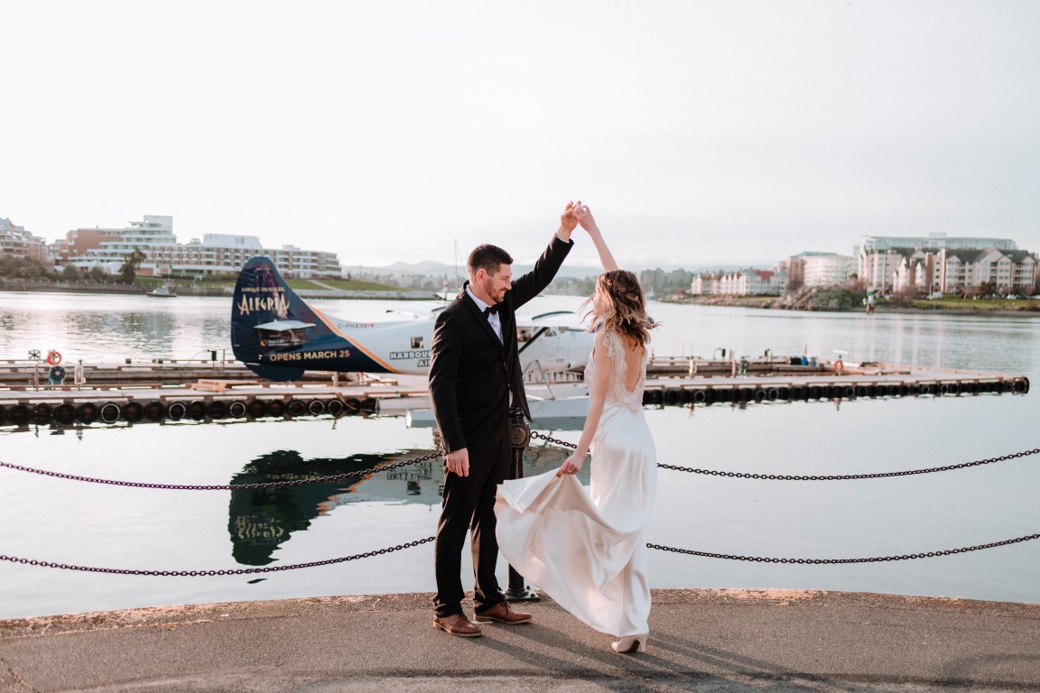 Ocean + Ink newlyweds dance on the dock by Harbour Hair seaplan on Vancouver Island