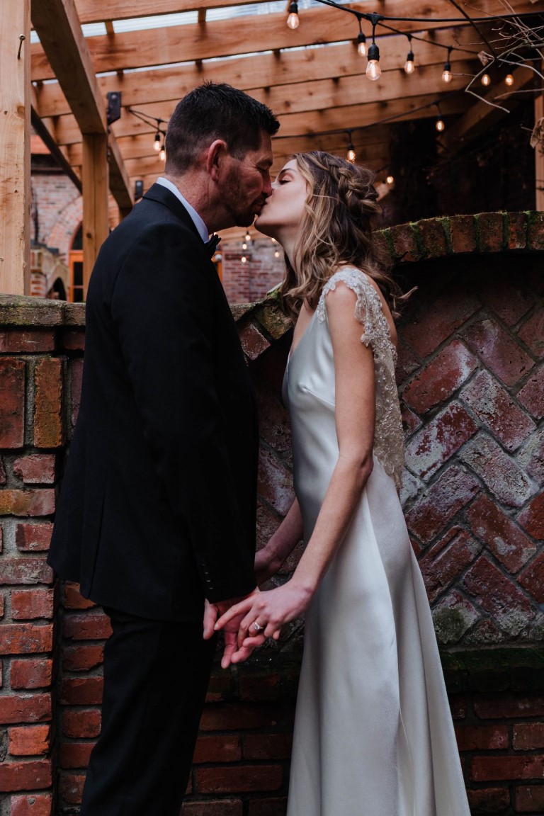 Newlyweds kiss in downtown Victoria on Vancouver Island by Megan Maundrell