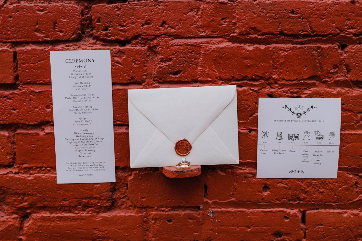 Invitations by Mango Ink on Vancouver Island against red brick wall