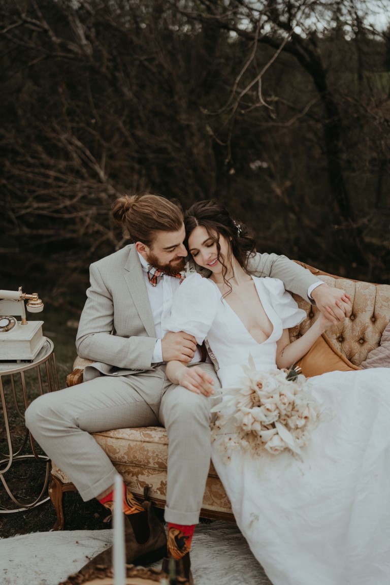 Vancouver Island newlyweds cuddle on vintage couch in outdoor lounge