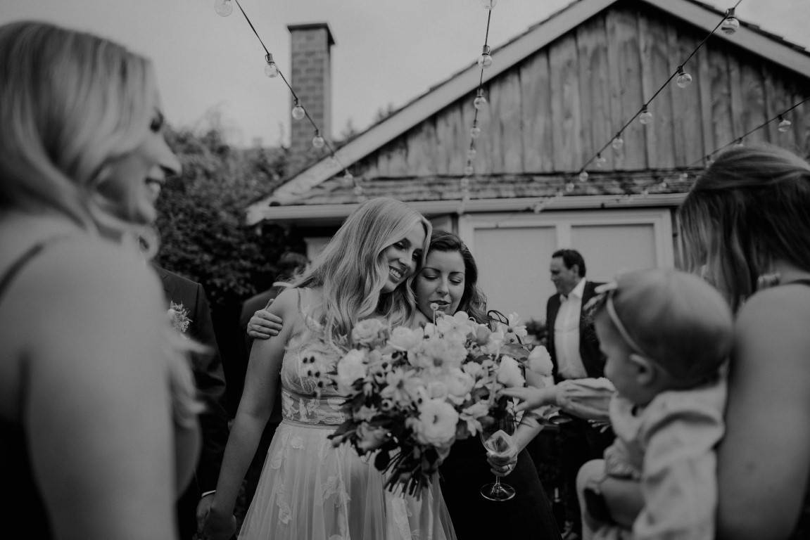Bride walks down the aisle with bouquet smiling at guests