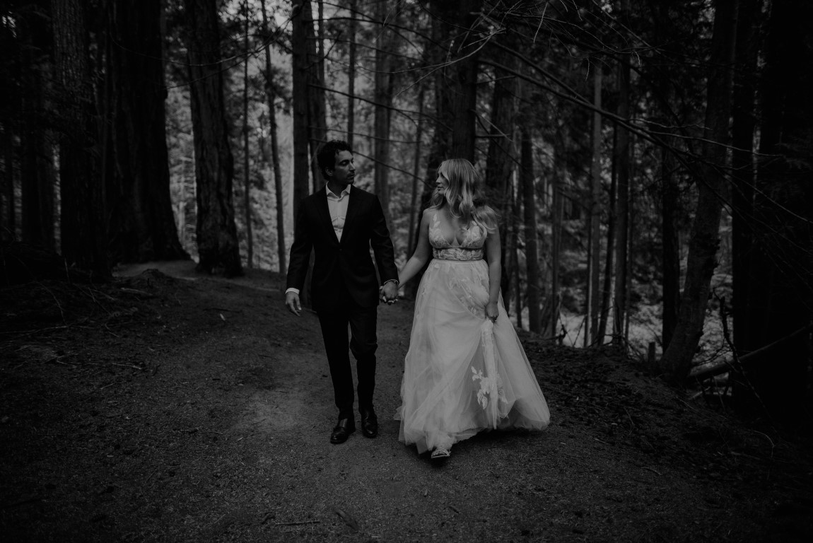 Bride and groom walk along forest path by Dallas and Sabrina
