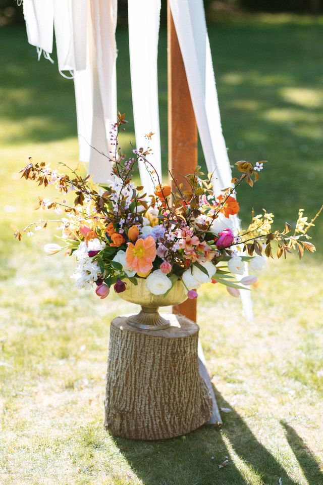 wild flowers amongst roses in stunning floral centerpiece on tree stump