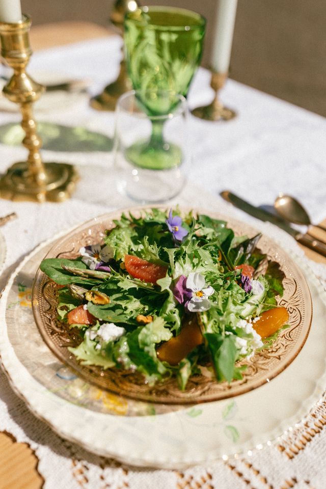 salad with edible flowers on neutral colored glass plate