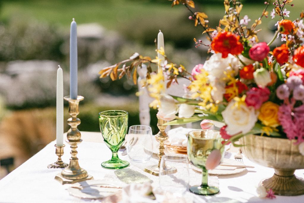 green glassware and brass candleholders holding tall tapered candles