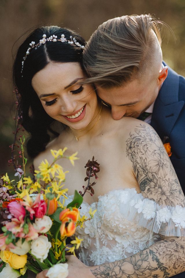 tender moment between bride and groom. Groom nestles her neck and shoulder