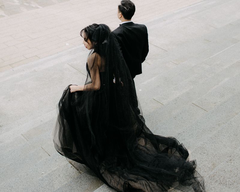 modern couple descends cement steps in downtown vancouver bride wearing black tulle couture gown