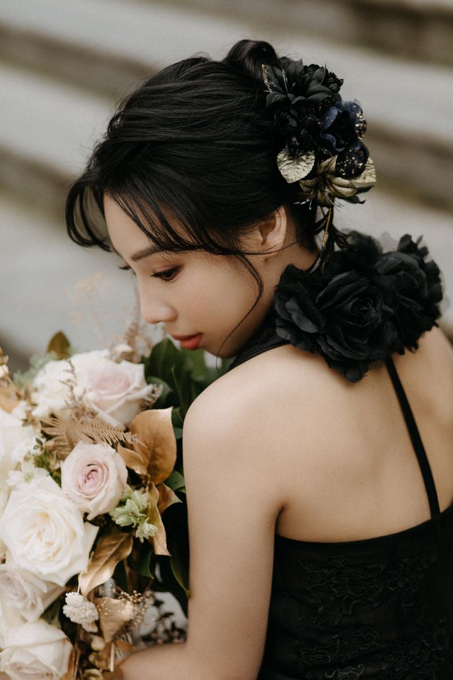 Bride with black floral detail on back of gown holds pale pink and neutral rose bouquet