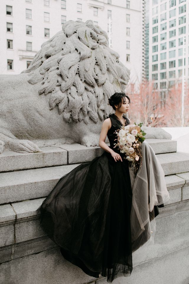 bride wearing black couture gown holding neutral floral bouquet