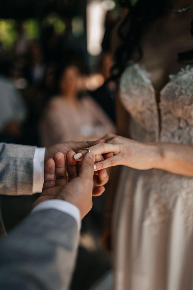 groom puts ring on brides finger