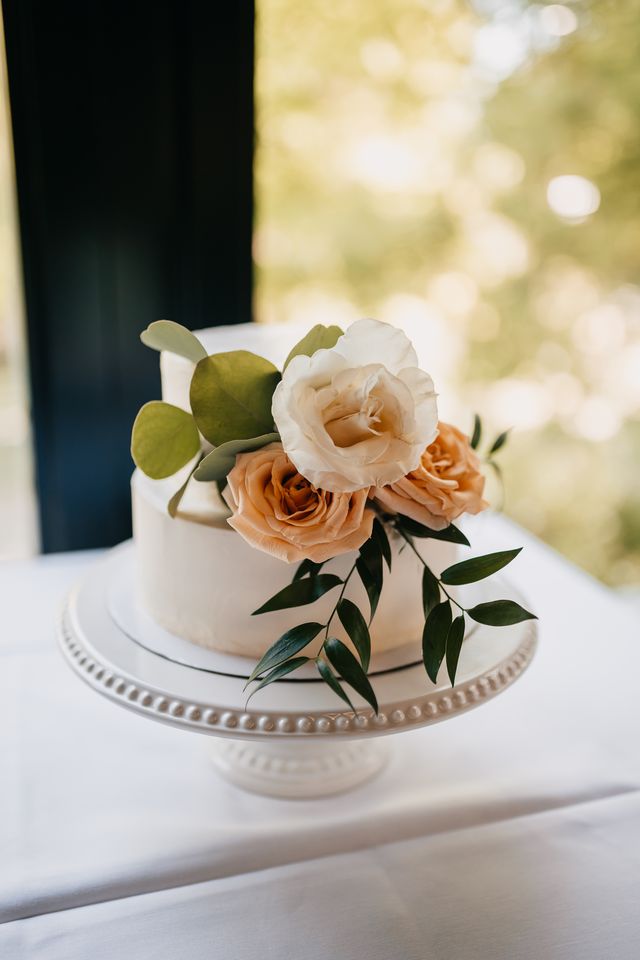 small round 2 tier wedding cake with fresh roses and greenery