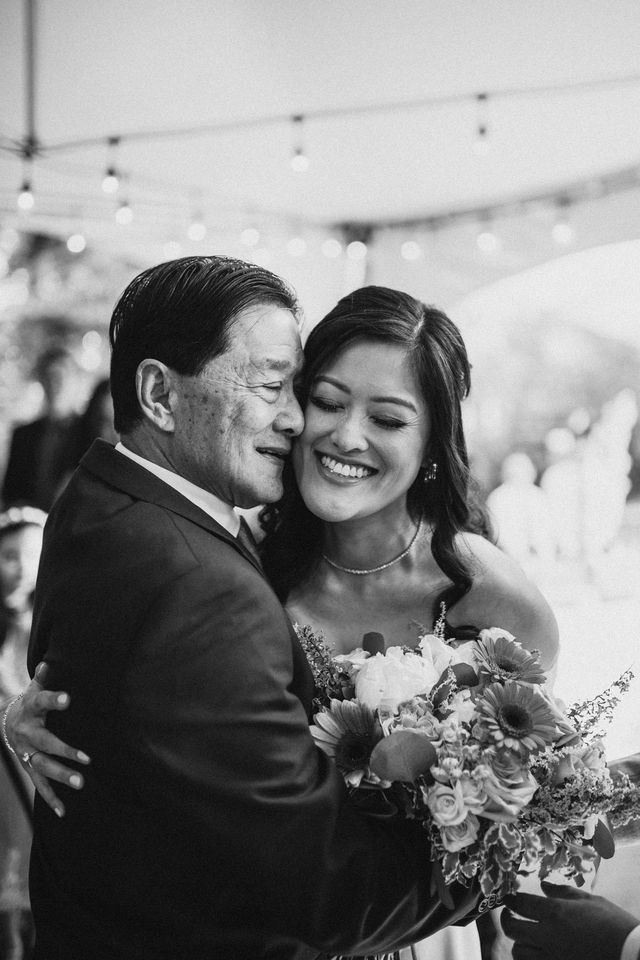 bride hugs father in black and white photo edit