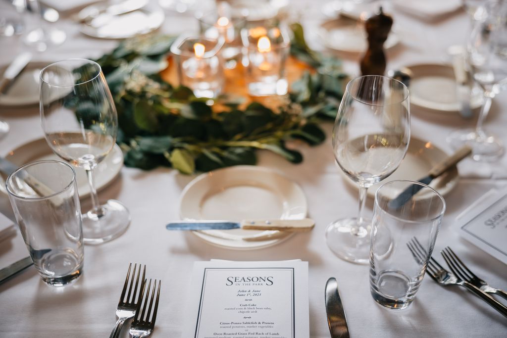 tablescape at seasons in the park venue , menu in foreground