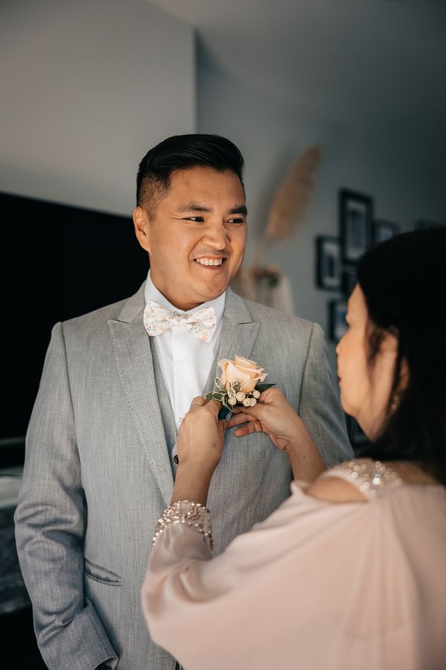 grooms mother put on his rose boutonniere