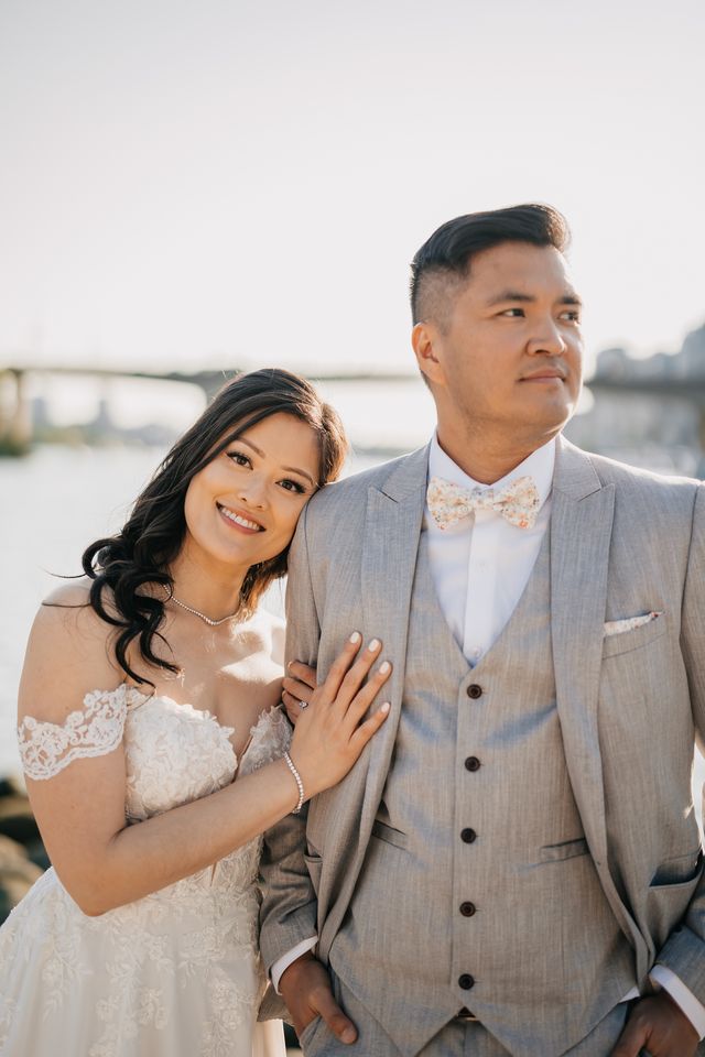 beautiful smiles from the bride leans her head on grooms shoulder as he looks on