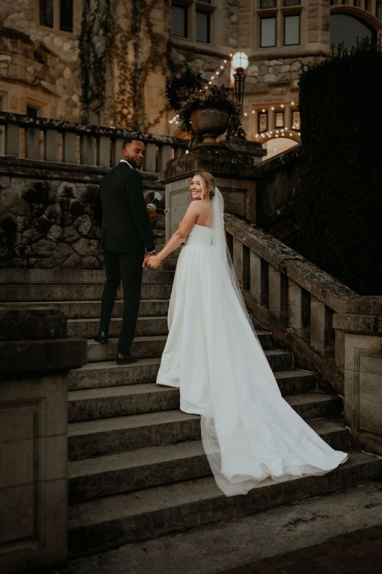 bride and groom walk up the steps to their reception on back veranda