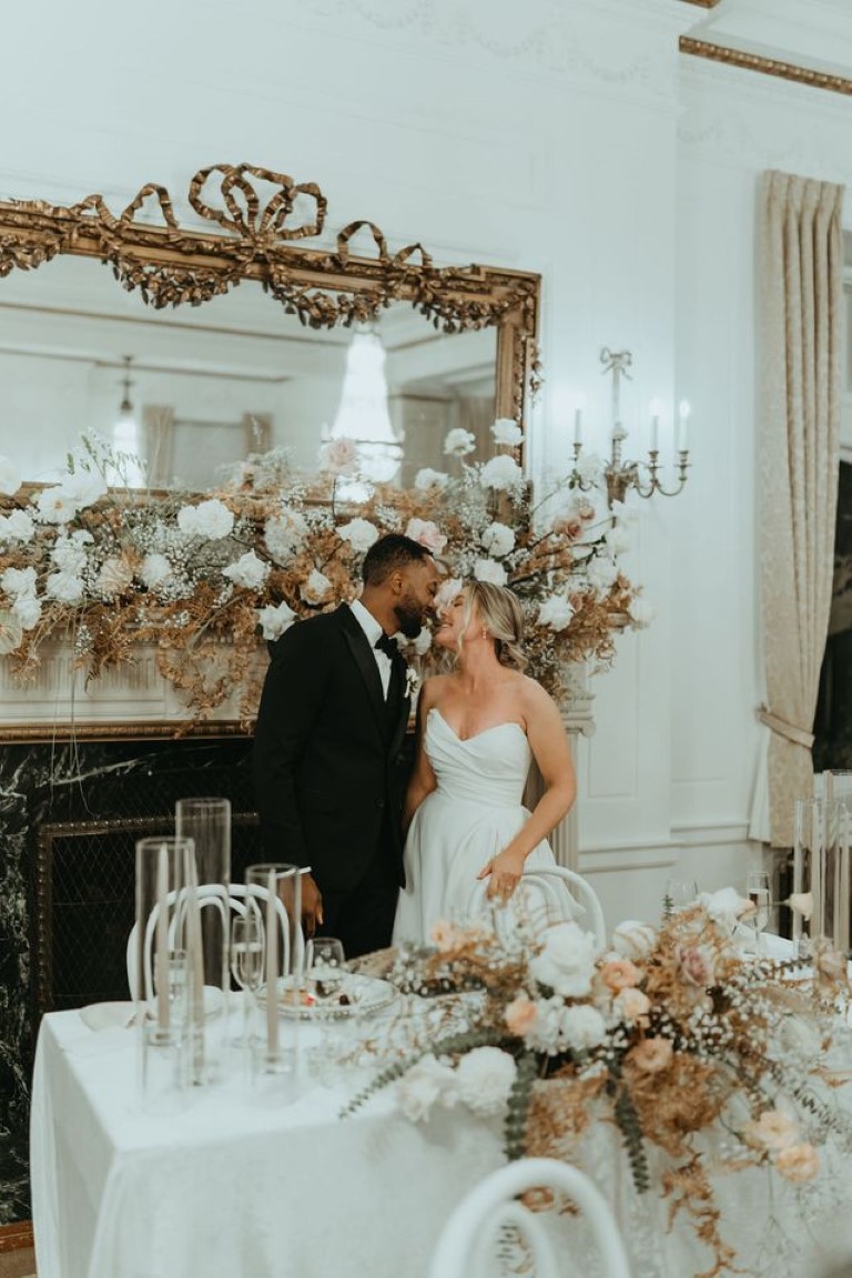 couple look into each others eyes behind the sweetheart table