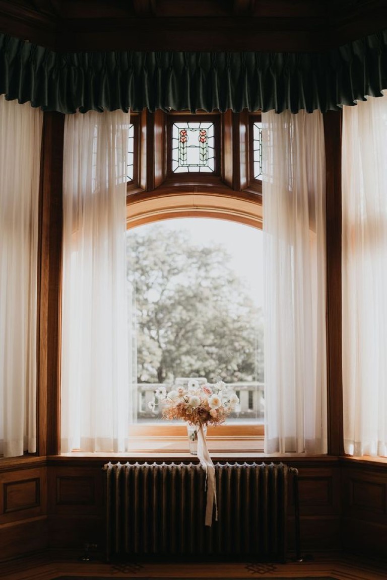 bridal bouquet in large window sill in hallway of Hatley Castle