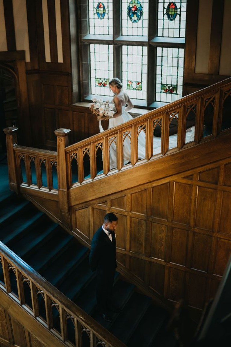 bride and groom descend steps inside the foyer of Hatley Castle