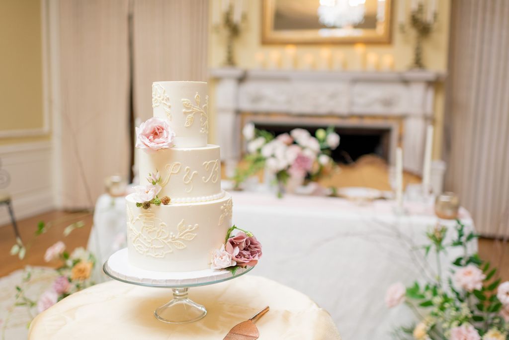 wedding cake sitting on small table with gold server