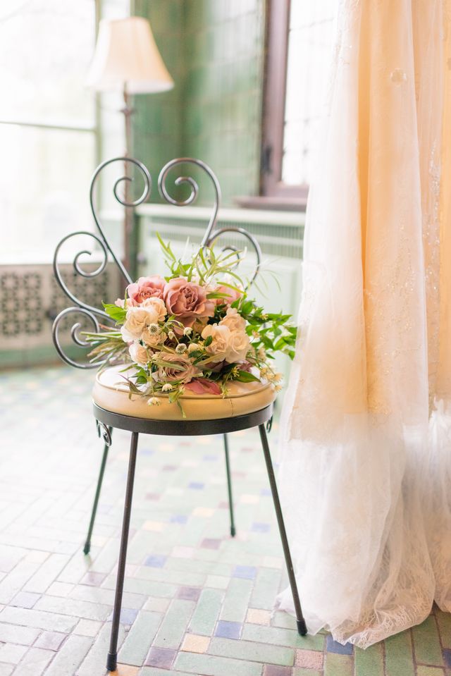 beautiful bridal bouquet on fancy chair with pale pink wedding dress