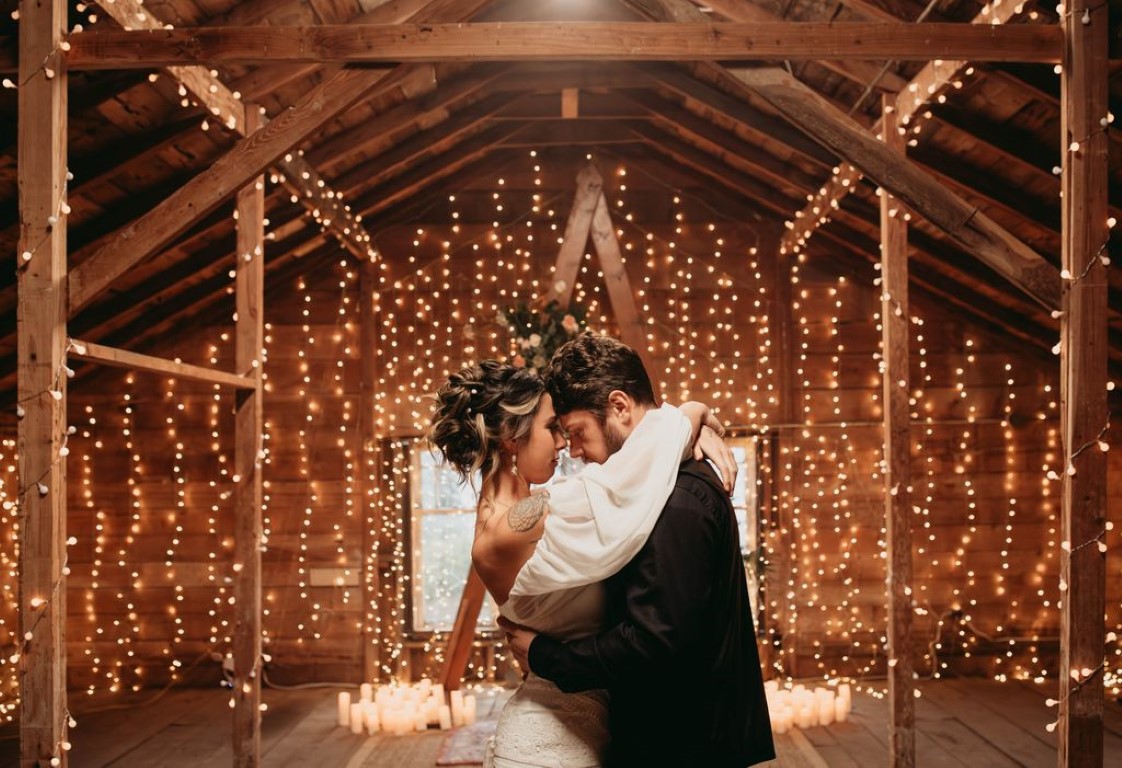 Newlyweds kiss surrounded by twinkle lights