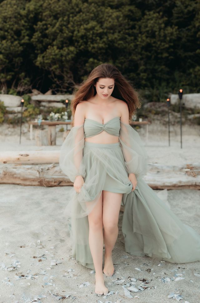 bride walks barefoot over shells and pebbles on beach