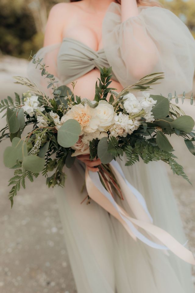 bridal bouquet in white neutral peach roses and ties with ribbon