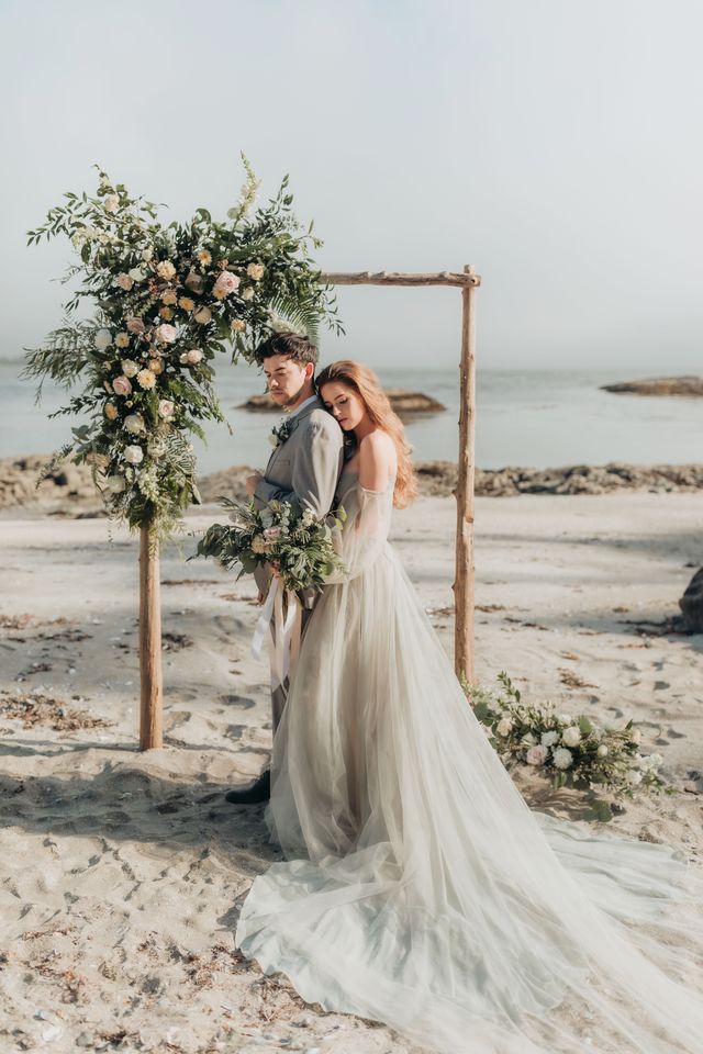 bride tucks in behind groom in-front of arch