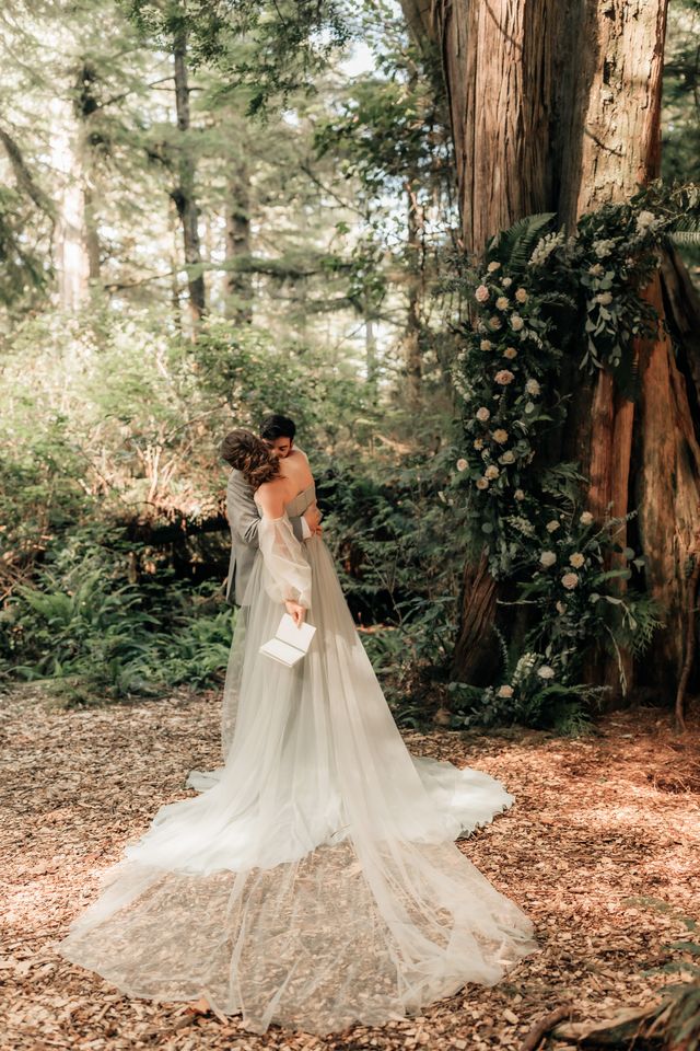 couple hugs as bride has vow book in-hand