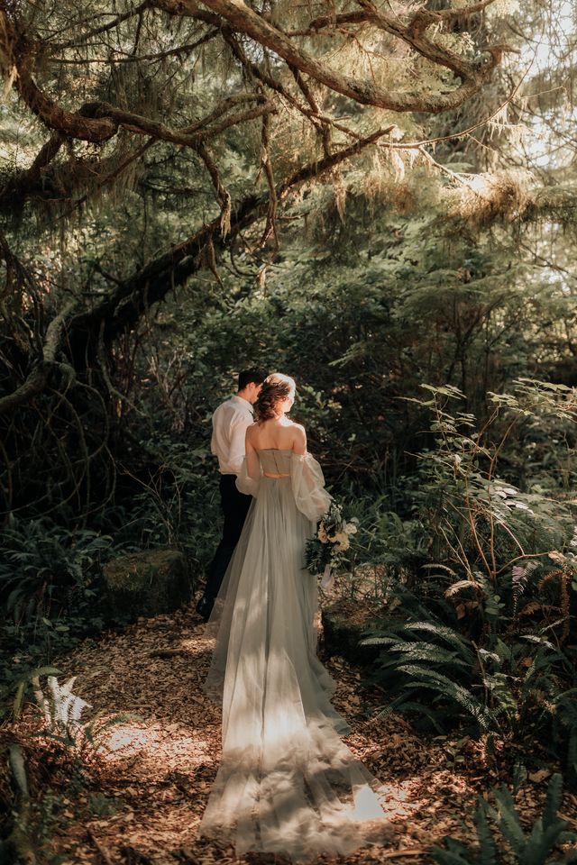 bride and groom walk through forest