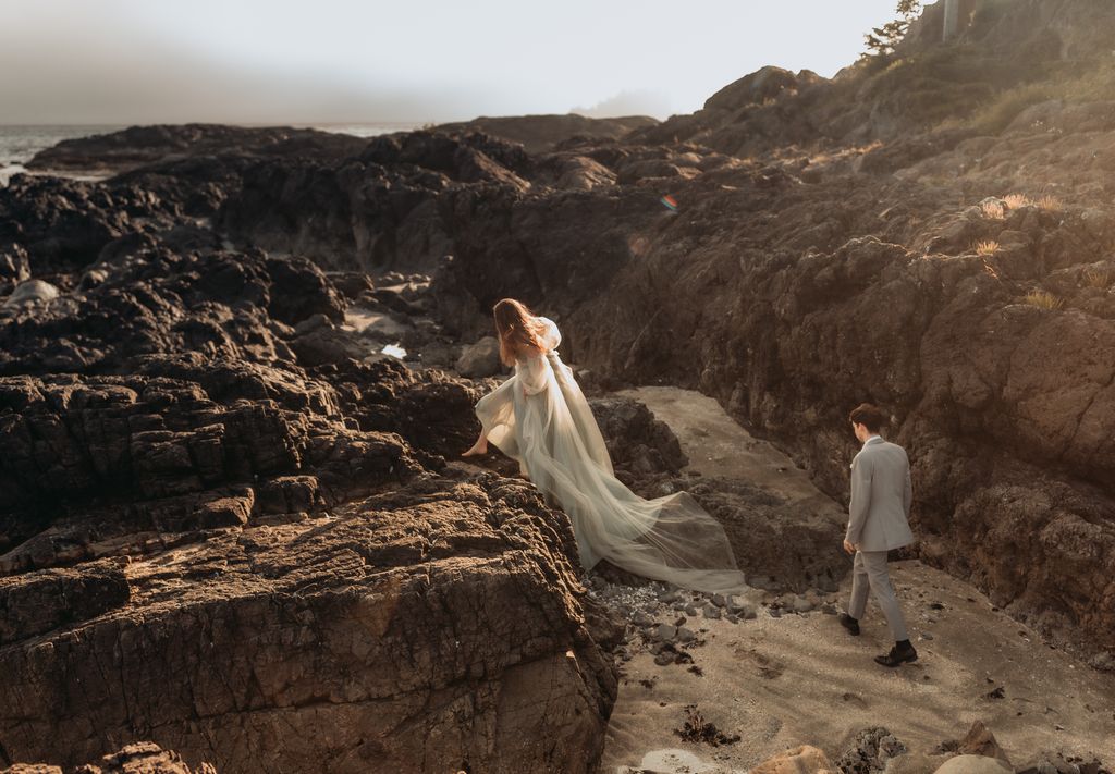 barefoot bride climbs large west coast beach rocks