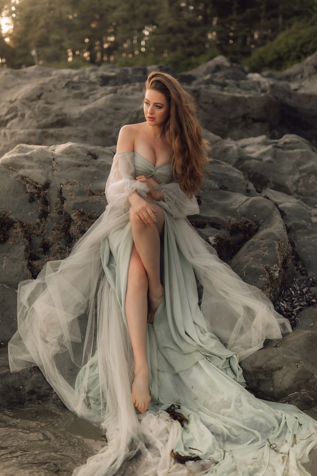 bride sit on rock with flowy gown