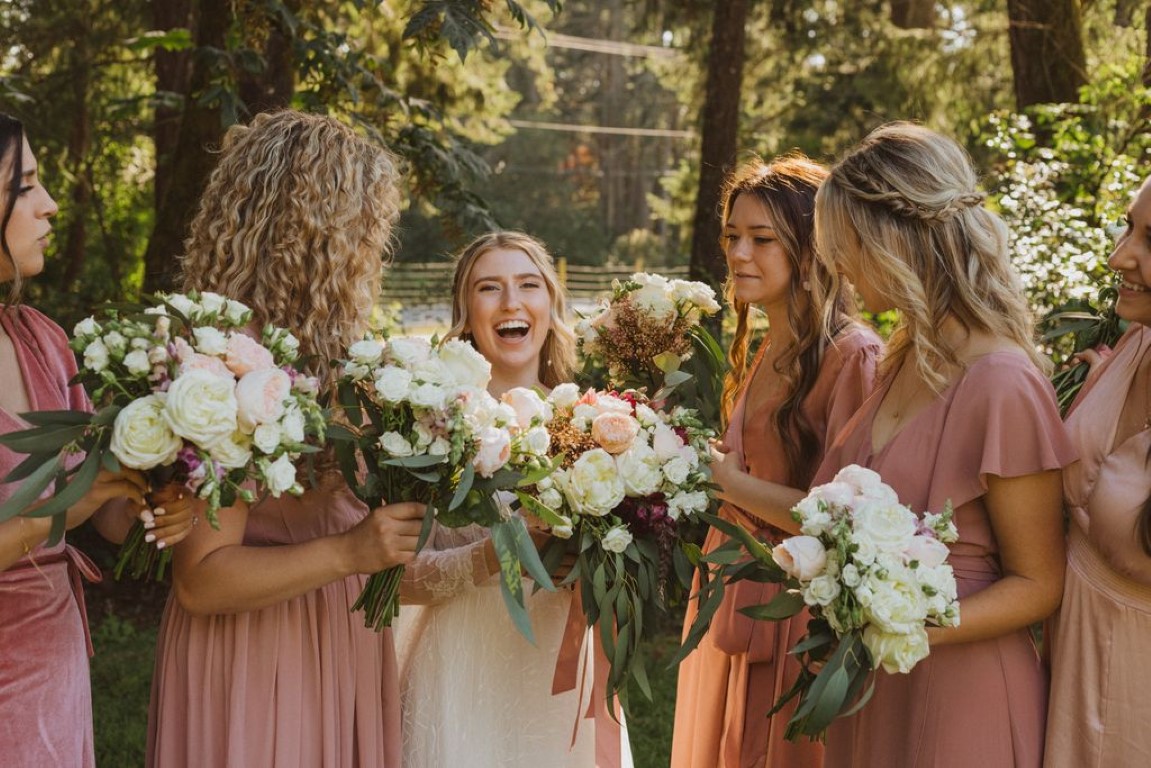 bride and her bridesmaids holding their floral bouquets before they go down the aisle
