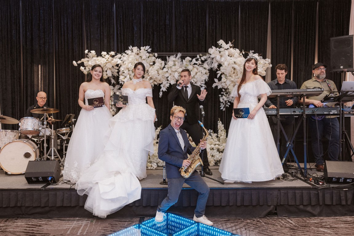 Bridal models and saxophone player on stage at West Coast Wedding Show Vancouver