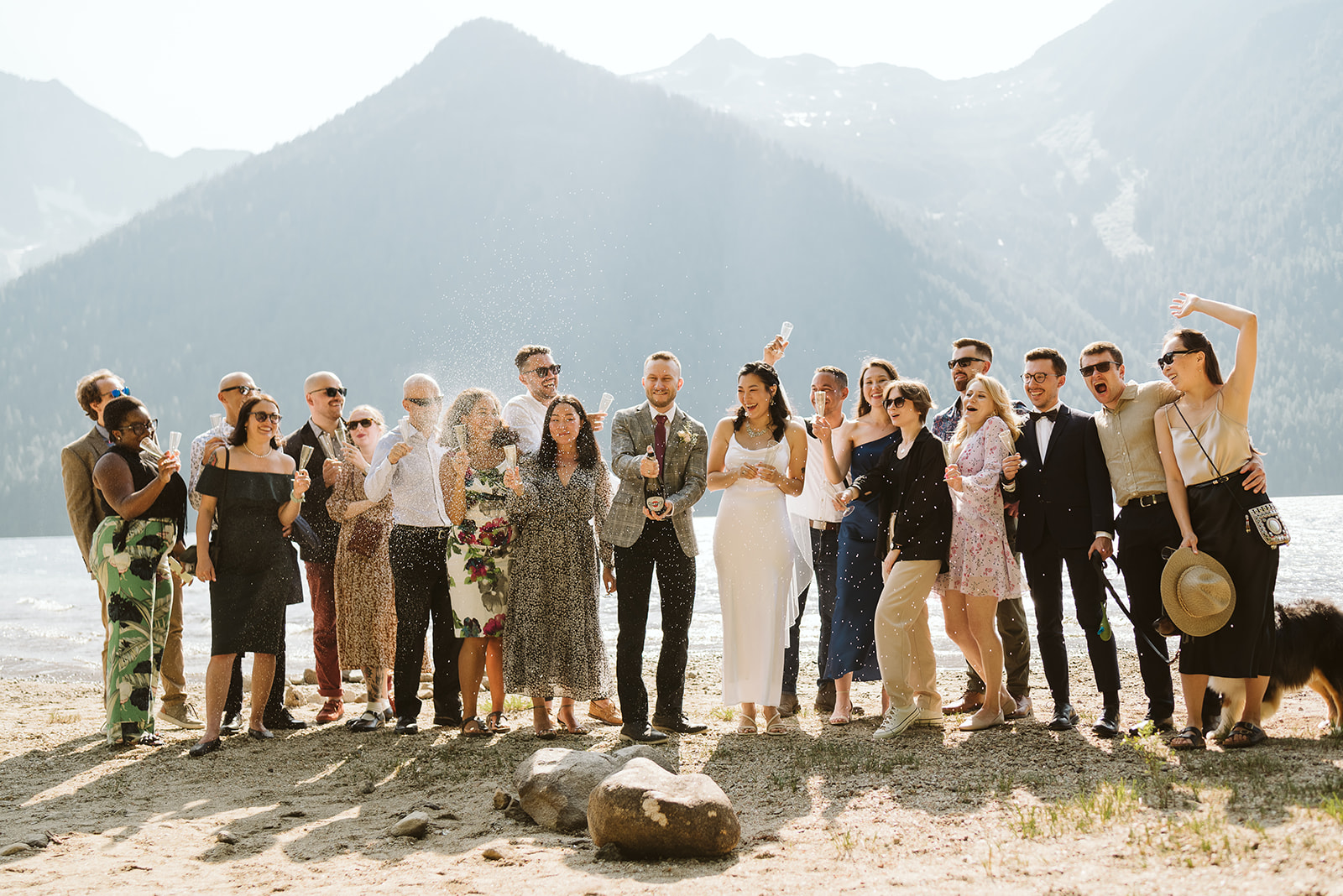 Group shot of wedding guests at mountain lake in BC