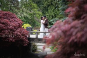 Newlyweds embrace on garden bridge in Vancouver