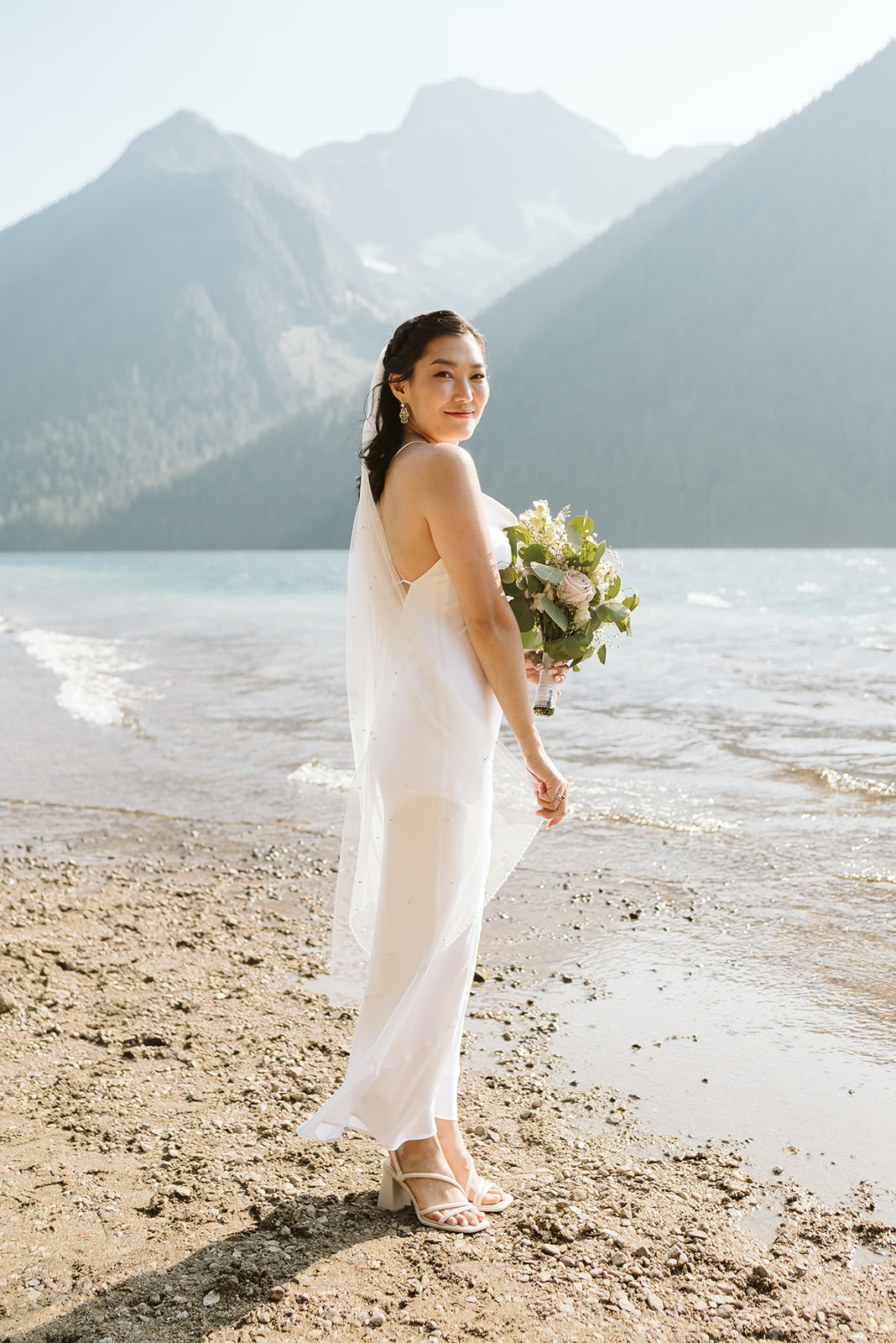 Bride on BC lake beach wearing Park & Fifth gown