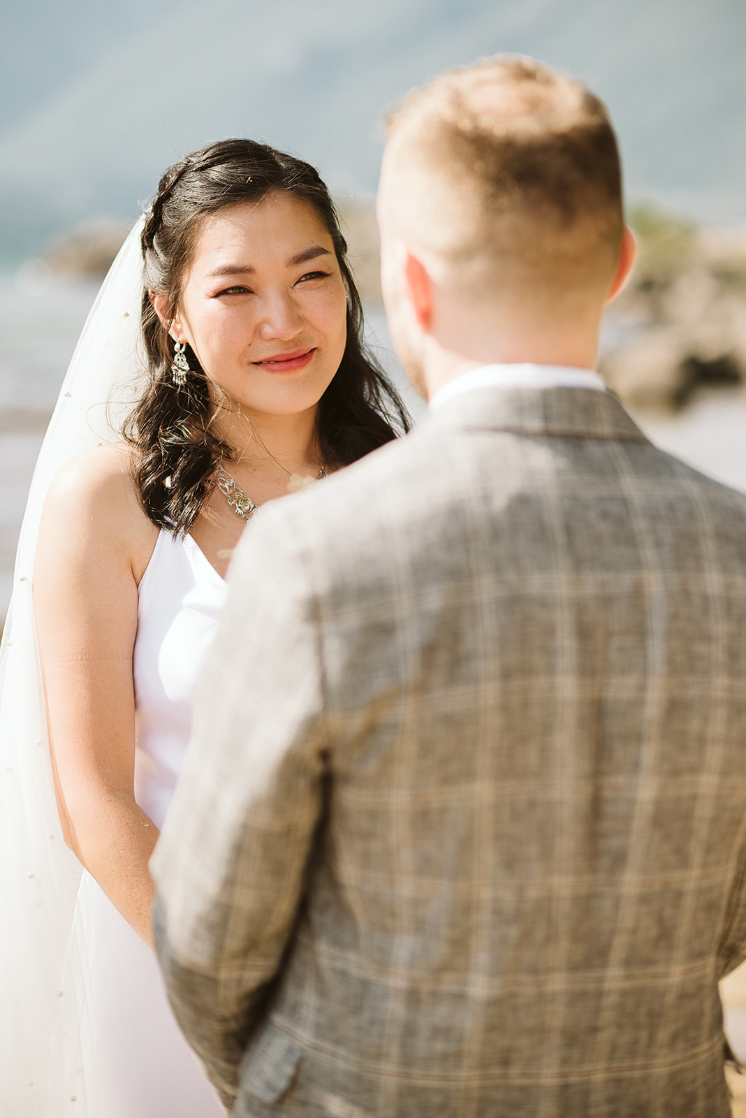 Bride and groom exchange vows in mountain lake wedding