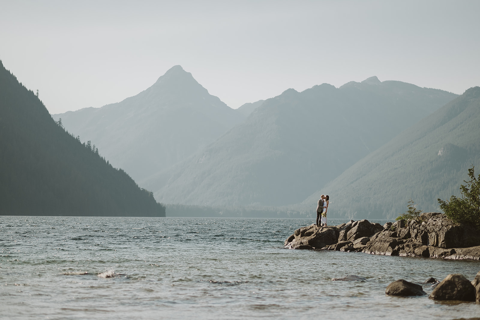 Newlyweds in front of mountain and lake in BC