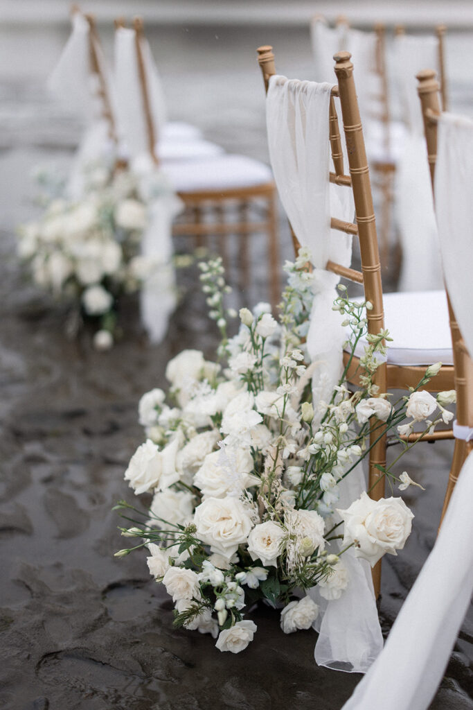 white roses cover gold Chiavari chair on vancouver beach