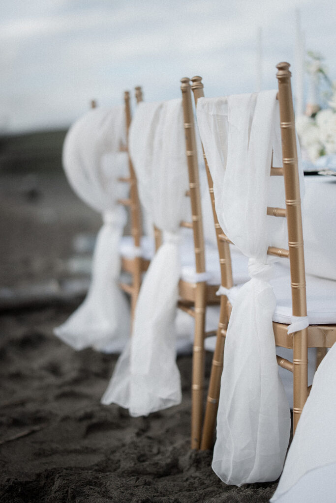 white fabric folded on Chiavari chairs on vancouver beach