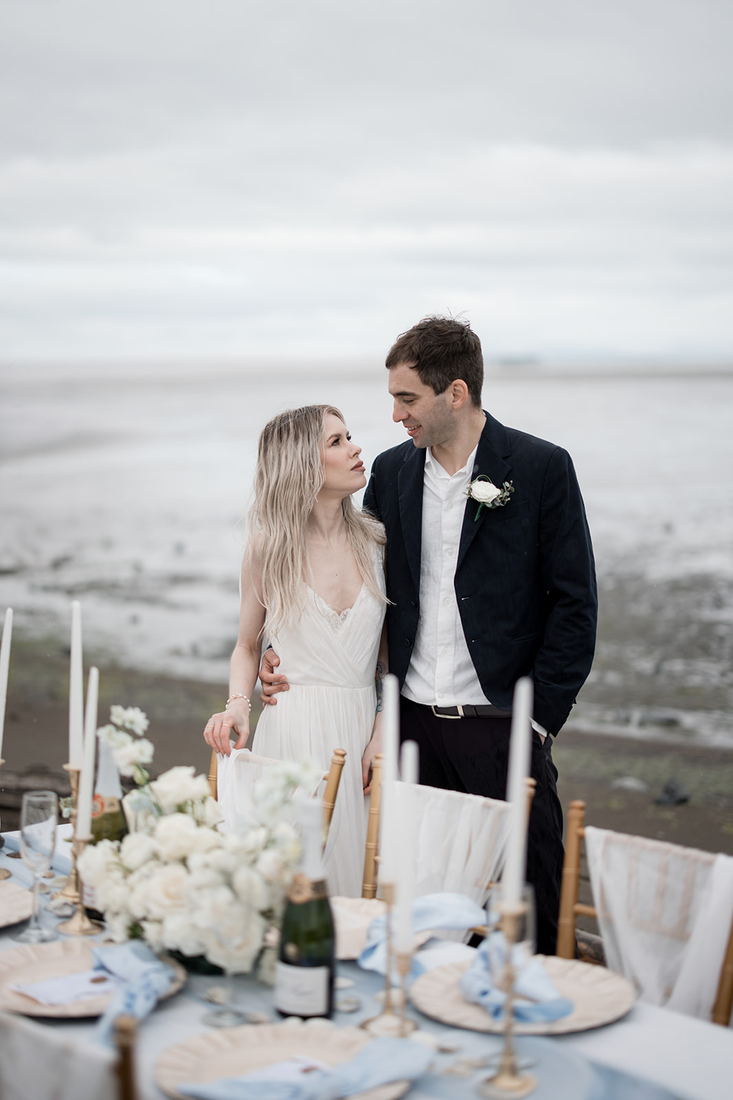 Wind + Water Wedding Inspiration newlyweds at sweetheart table on Vancouver beach