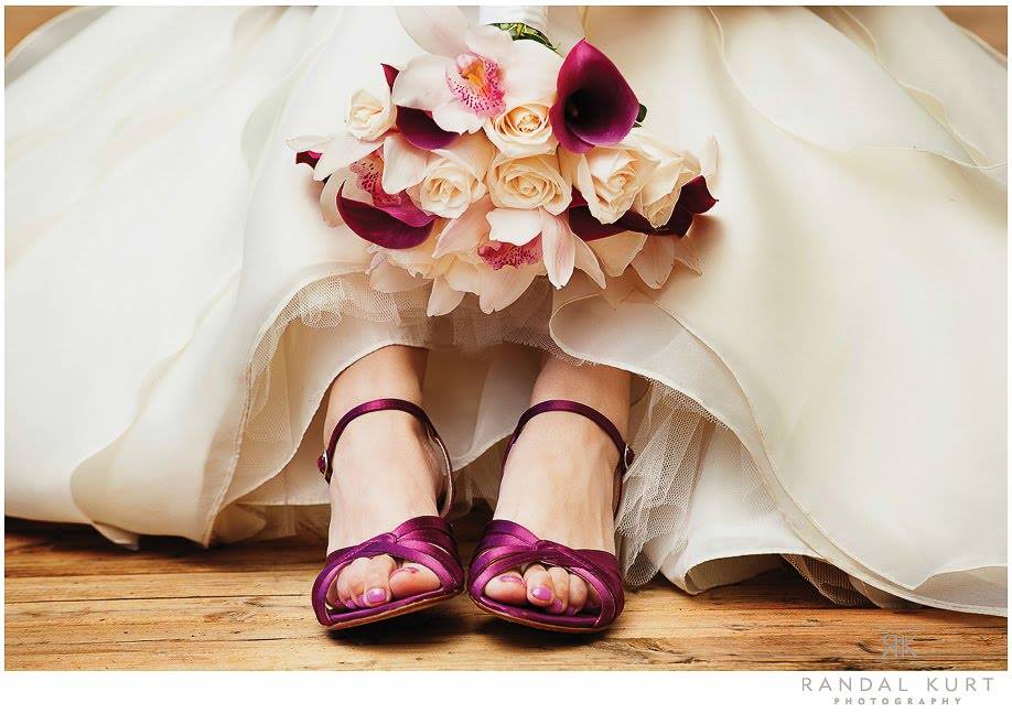 Bride holds orchid bouquet between red shoes PROLINE Vancouver