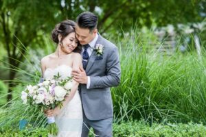 Newlyweds with white orchid bouquet by PROLINE Floral Artistry