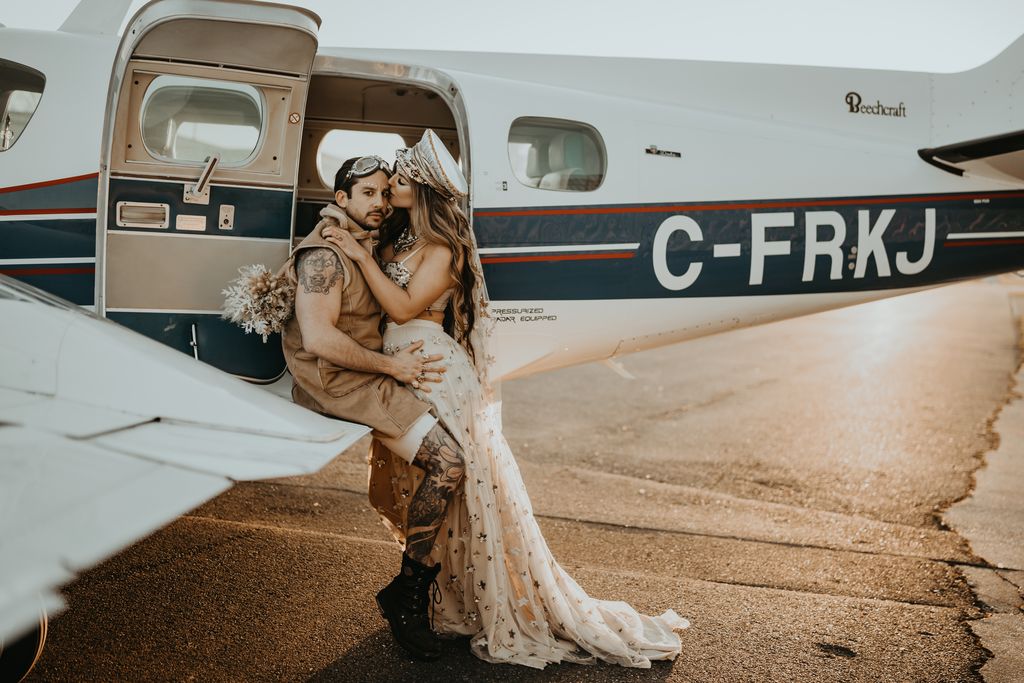 Newlyweds embrace on airplane wing