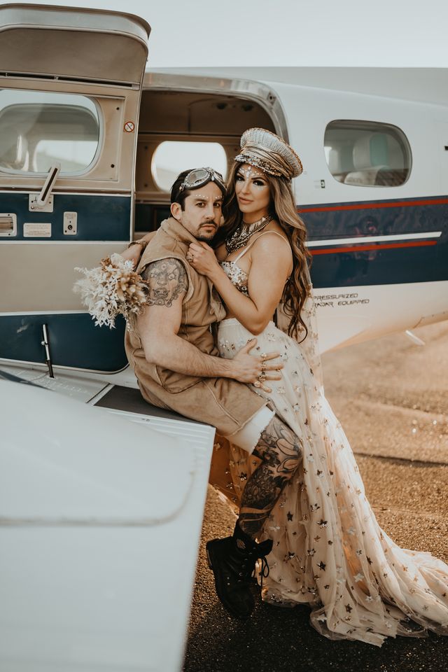 Bride and groom sit on airplane wing