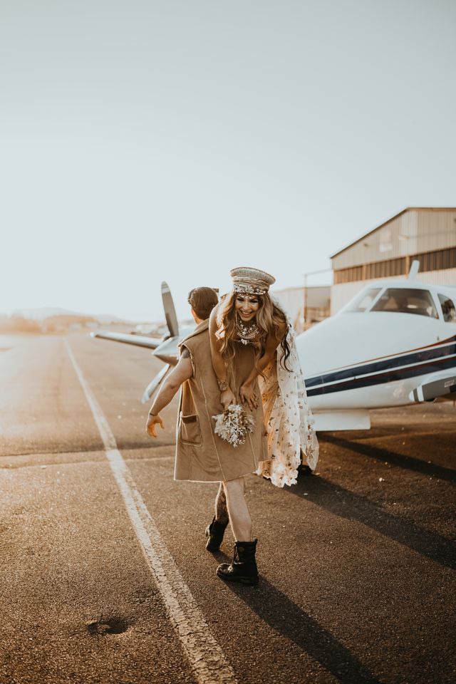 Groom carries bride down runway