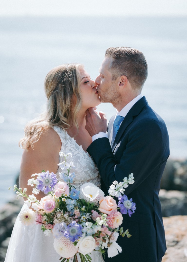 Newlyweds kiss with Victoria Harbourfront behind them