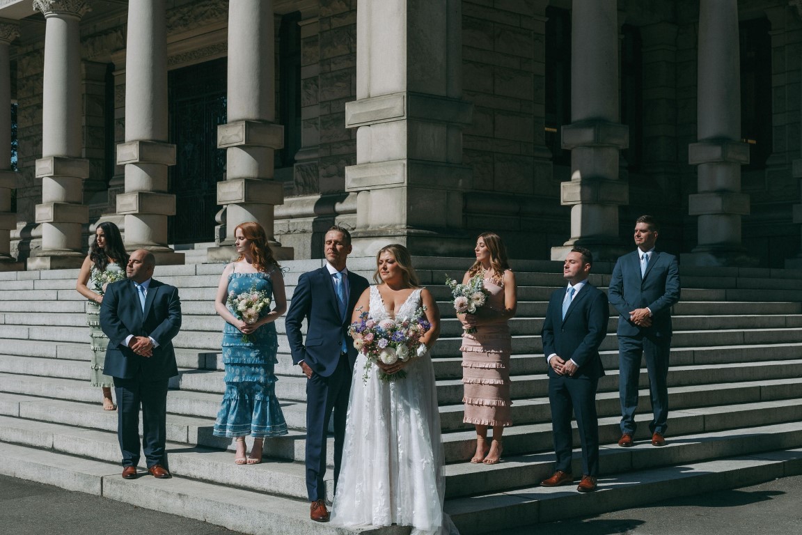 Wedding Party stands on the steps of Parliament Buidlings Vancouver Island